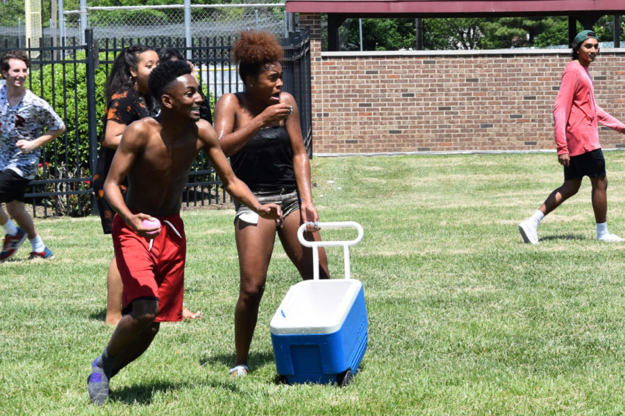Mouth dropping in shock, junior Harmauhny Faulkner clutches onto a cooler full of water balloons as she is pelted by her classmates. The Junior Class began the tradition of a water balloon fight on the last day of school as a way to kick off their last summer before senior year. It felt like I was growing up because I only have one year left until I graduate, Faulkner said. My favorite part was running away from the boys who were trying to dump water on me; even though I knew it was coming I was shocked that some of them were throwing the balloons so hard.