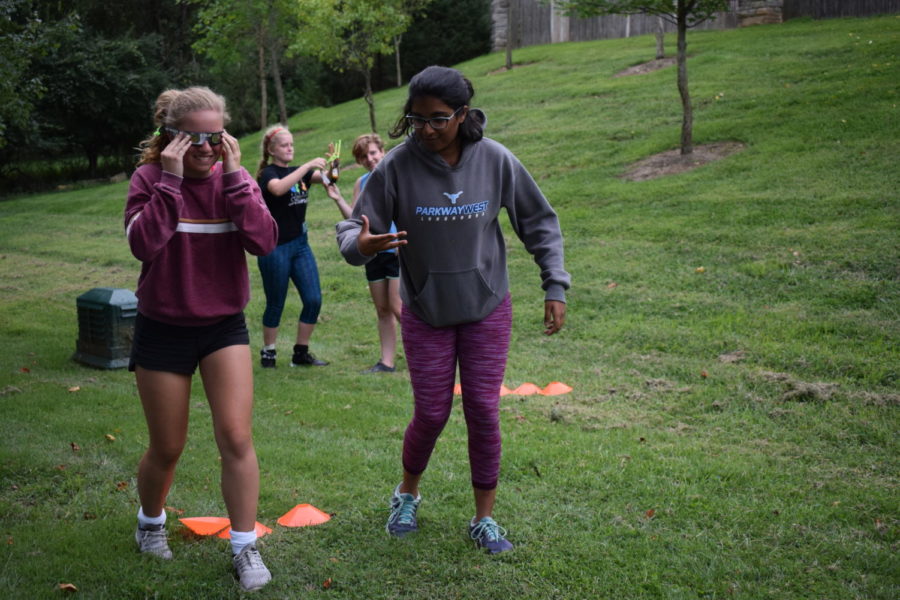 Navigating+an+obstacle+course%2C+sophomores+and+JV+field+hockey+players+Haley+Keller+and+Rishita+Nannapaneni+work+together+to+compete+against+their+teammates+in+a+bonding+exercise.+In+preparation+for+their+first+game+of+the+season+Aug.+24%2C+both+the+JV+and+Varsity+teams+got+together+for+their+annual+Pasta+Night+dinner+at+their+Head+Coach+Dawn+Callahan%E2%80%99s+house.+%E2%80%9CI+really+wanted+to+win+because+I%E2%80%99m+really+competitive%2C+but+it+was+hard+with+those+eclipse+glasses+on%2C%E2%80%9D+Nannapaneni+said.+%E2%80%9CI+loved+bonding+with+the+team.+In+order+to+play+good+as+a+team%2C+you+have+to+be+connected+outside+of+the+game+because+then+you+know+you+can+rely+on+them+to+be+there+for+you+in+the+game+and+in+real+life.%E2%80%9D+