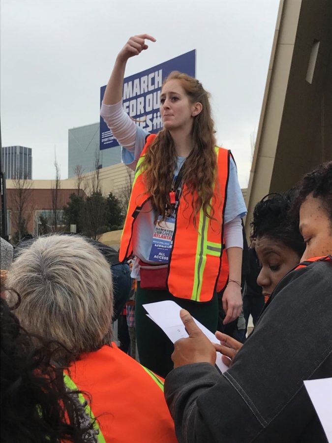 Directing the crowd, alumna Shannon Anderson leads marchers along the route for March For Our Lives in Atlanta, GA.