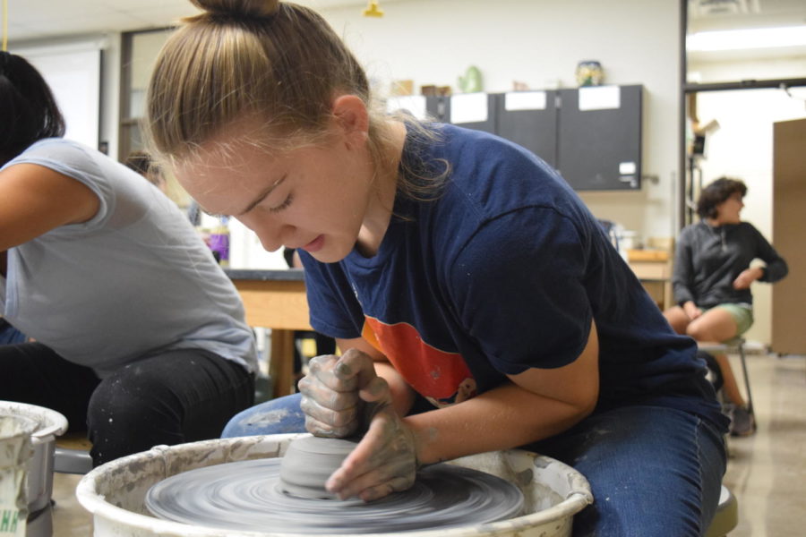 Molding the center of a clay bowl, sophomore Megan Gordon leans over a pottery wheel in Clay Club. Although Gordon just started experimenting with clay, she has created art with other mediums like paint and is currently taking ceramics. “I’m not very good with words, and I’m not very good with writing things down because of my dyslexia,” Gordon said. “I’m better with painting a picture because I learn very visually, so I’m able to transfer that to the picture. I feel like sometimes my art can speak for me.”