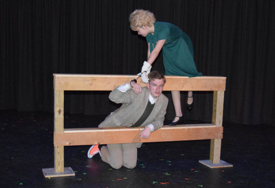 Scaling a fence while handcuffed, sophomore Arden Dickson and senior Hayden Riehl perform a scene from The 39 Steps. Among the characters Riehl portrays is Richard Hannay, a British man attempting to hide from law enforcement after being accused of murder. “[Hannay is] this really high energy, ‘stick-in-the-mud’ type character,” Riehl said. “He is super exhausting to play because of all the running I do, but he’s just got a really fun properness to him that completely contradicts all the wildness around him.”