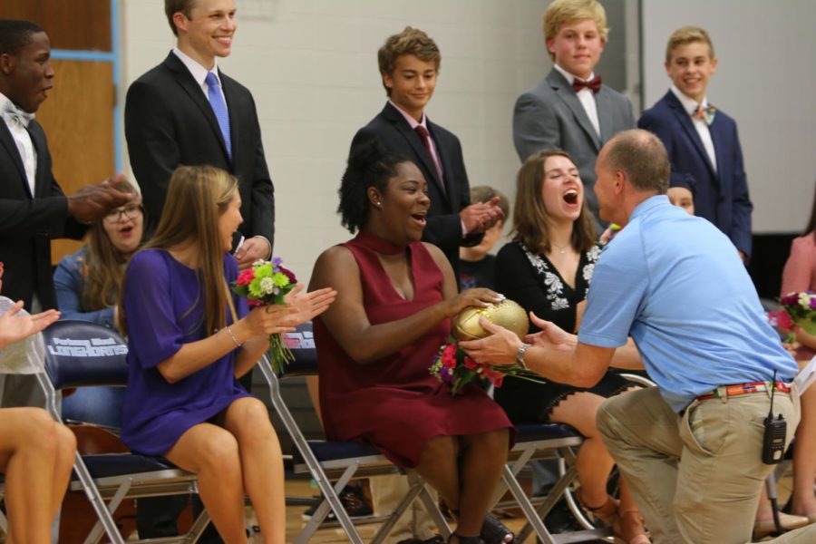 Receiving the golden football, 2018 alumna Erica Jones becomes Homecoming Queen during the 2017 fall pep rally.