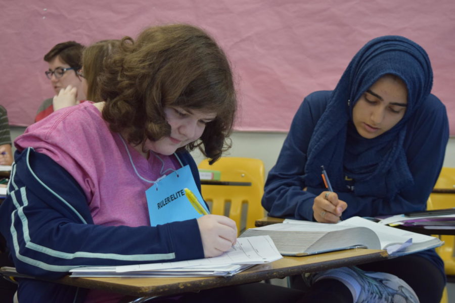 Acting as a “ruler” in an AP World History class activity, sophomore Ayra Ali interacts with sophomore Sarah Hall and other students in a social hierarchy activity in which they took on the roles of various people in ancient societies. The activity allowed students to better understand the differences between people in different social classes. “It made me more aware of what life was like in the past, like how women had no rights and peasants didn’t have many either,” Ali said. “[As a ruler] I had way more privileges than the rest of my class and they couldnt do as much as I could.”  