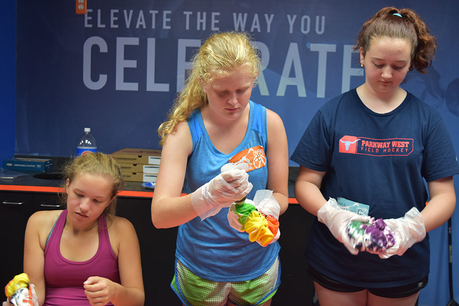 Focused on the task at hand, sophomores Haley Keller, Karen Trevor-Roberts and freshman Sarah Kline tie-dye shirts at Sky Zone following their workout class on the trampolines. The team also ate pizza and attempted the new Ninja Warrior obstacle course. “We thought it would be fun to tie-dye our team shirts so we could wear them to school on days when we have games. They have our last name and number on the backs,” Keller said. 