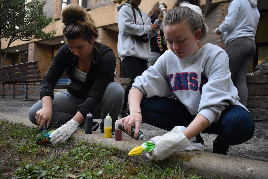 Squatting+in+the+Peace+Garden+Wed.%2C+Oct.+17%2C+senior+Brianna+Vietmeier+and+senior+Women+of+West+Officer+Jessica+Goedeke+tie-dye+shirts.+In+an+effort+to+create+a+sense+of+community%2C+30+members+met+at+7+a.m.+to+talk%2C+tie-dye+and+bond.+%E2%80%9CWe+wanted+girls+to+feel+supported+and+comfortable+coming+to+the+club+and+listening+in+on+their+experiences%2C%E2%80%9D+Goedeke+said.