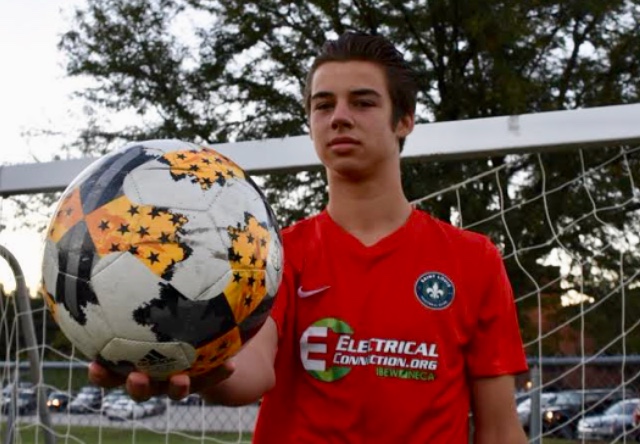 Holding up a soccer ball, junior Jansen Miller dons his soccer jersey in front of a goal. Jansen has played soccer with the St. Louis Football Club Academy for three years. “The advantage is that [STLFC] are good role models, who have helped me not just in soccer, but in life as a professional because thats their job. Thats their life and thats what I want to do,” Miller said. “Seeing them and what they do every single day, thats my goal.”