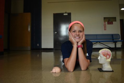 Freshman Giselle Bauer poses with a model of the human brain. Bauer has a brain tumor that causes seizures and has undergone four surgeries to minimize the tumors size and effects. Even though some things are harder, I know I can function normally, Bauer said. I try to forget my tumor’s there and know that I’m just the same as everyone else.