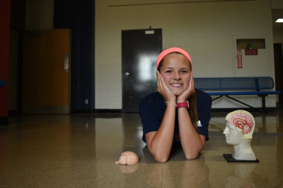 Freshman Giselle Bauer poses with a model of the human brain. Bauer has a brain tumor that causes seizures and has undergone four surgeries to minimize the tumor's size and effects. "Even though some things are harder, I know I can function normally," Bauer said. "I try to forget my tumor’s there and know that I’m just the same as everyone else."