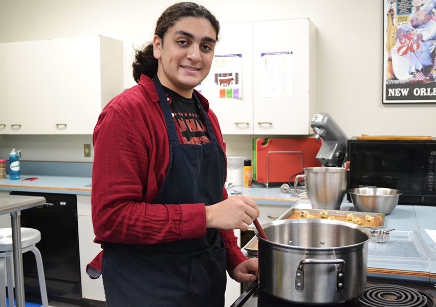 While Cadet Teaching in Culinary Arts, Zander Lionelli stirs homemade spaghetti sauce.