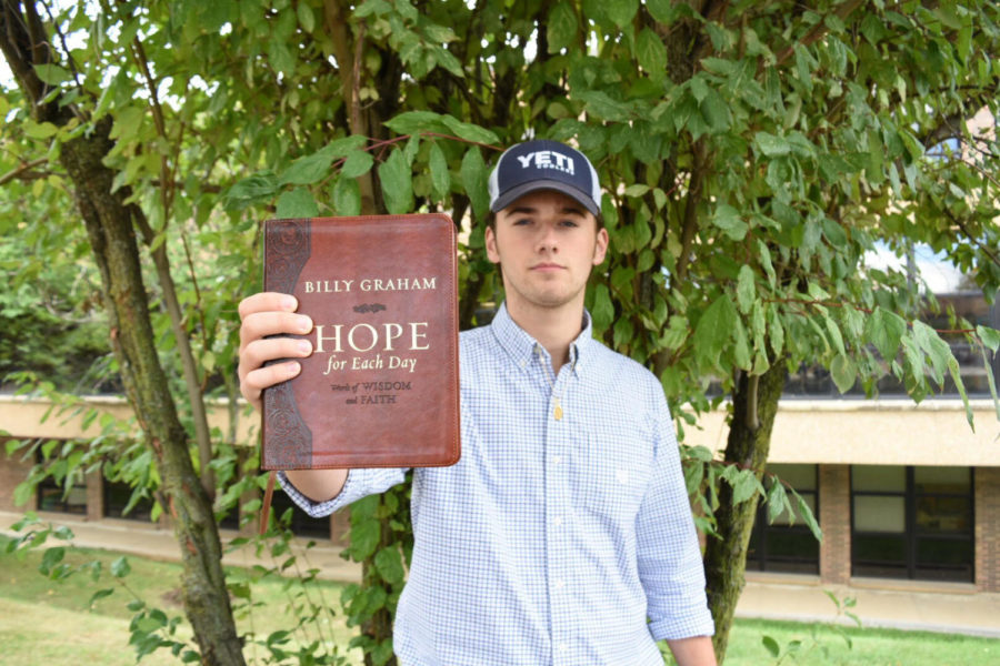 Holding up a Billy Graham devotional book, senior Will Creemens proudly displays his faith. Each day, he reads the devotional and accompanying verses for that day. "There's a lot in [the book] about accepting the people around you which we don't always do," Creemens said. "We're in such a divided world, so it's refreshing to have a devotional saying what God wants us to do and a verse that explains it too."