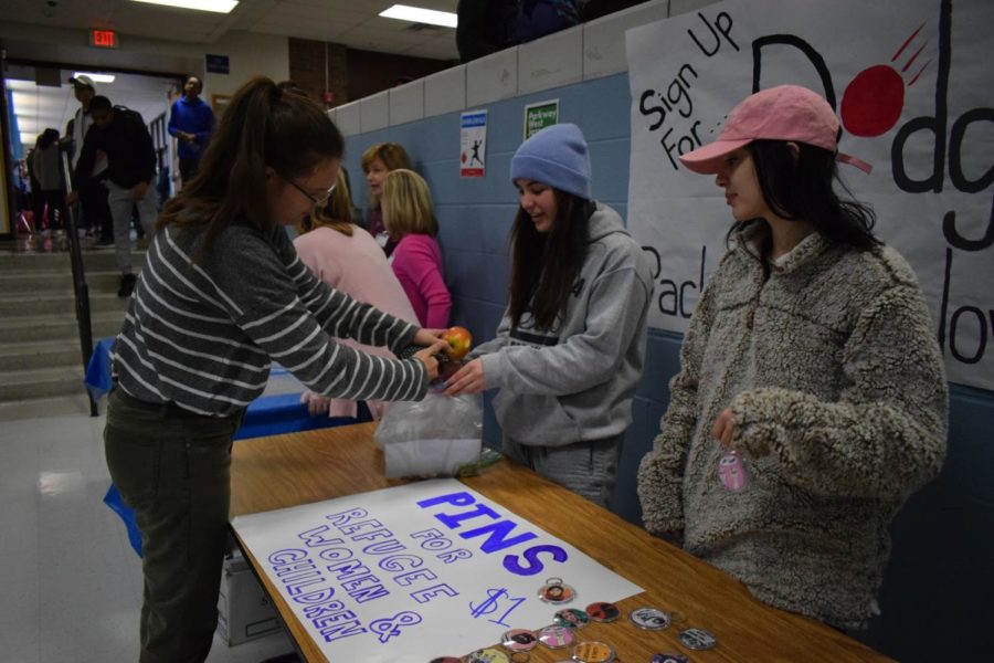Buying+a+pin+from+seniors+and+Feminist+Club+co-leaders+Lizzy+Calvert+and+Allani+Gordon%2C+senior+Kaitlyn+Taylor+helps+Feminist+Club+in+their+mission+to+donate+money+towards+immigrant+and+refugee+women+and+children.+The+club+sold+pins+and+keychains+for+%241+each.+%E2%80%9CThe+concept+of+being+active+in+West%E2%80%99s+community+and+volunteering+in+West+County+and+the+St.+Louis+community+is+a+great+experience%2C%E2%80%9D+Calvert+said.+%E2%80%9CTo+be+able+to+donate+money+to+a+program+that+will+benefit+women+and+others+is+always+a+nice+feeling.%E2%80%9D
