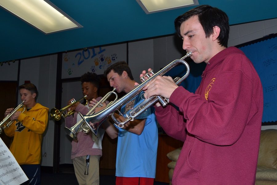 Focused+on+his+music%2C+senior+Noah+Wright+plays+his+trumpet+alongside+the+rest+of+trumpet+section+during+his+second+hour+class.+Wright+has+been+playing+in+the+Jazz+Band+since+his+sophomore+year%2C+but+this+is+his+first+year+playing+with+a+full+instrumentation.%E2%80%9CWith+there+being+more+people%2C+we%E2%80%99ve+really+been+able+to+push+ourselves%2C%E2%80%9D+Wright+said.+%E2%80%9CWe+really+have+depth+in+the+parts.%E2%80%9D