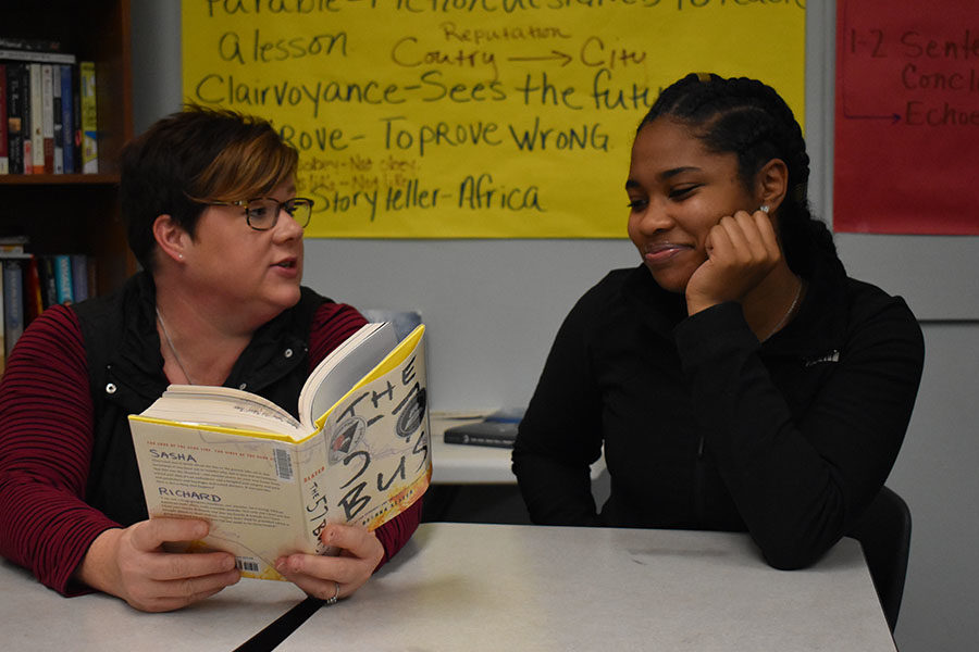 Book in hand, NEHS sponsor and English teacher Kim Hanan-West discusses with sophomore Trinity Peoples. When former student, Gabe Davis asked Hanan-West about an English honors society, Hanan-West did some research and started applying to NEHS. “I would encourage any student who is passionate about books, literacy and writing to apply,” Hanan-West said. 
