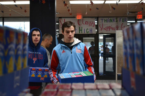 Carrying boxes of food raised in the annual history canned food drive, seniors Bailey Silva and Chris Kastberg add to the growing pile of over 3,500 cans. “It’s really important to help other people who might have less than we do. Bringing in a few cans seems like a really small thing but it can add up and do a lot to help other people,” Silva said. 