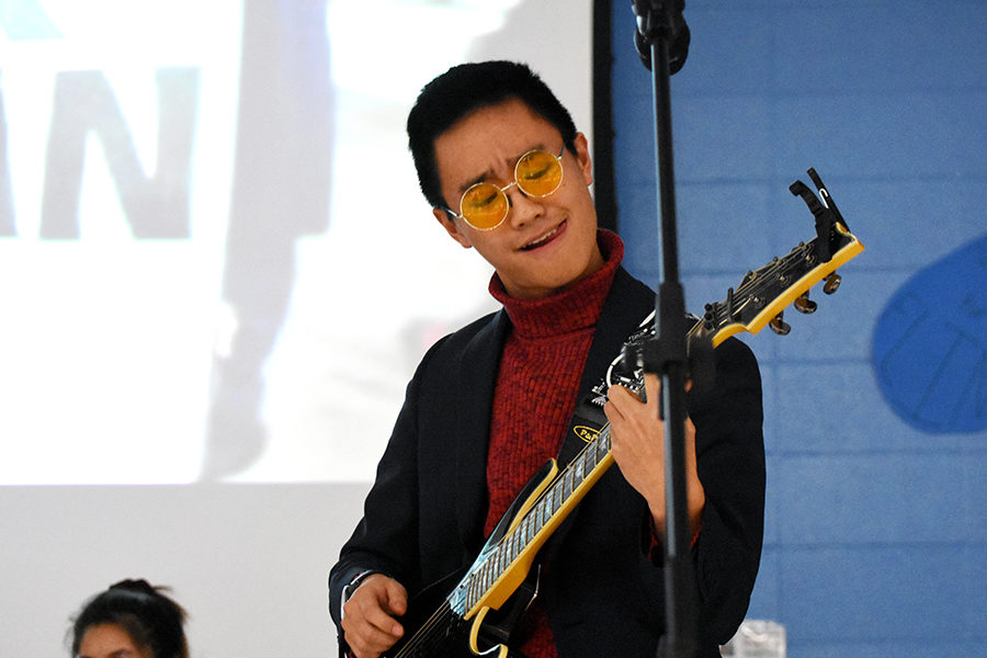 Strumming with his left hand on the neck of the guitar, junior Jon Ma plays with his band Stir Fry at the Flint, Mich. benefit concert Dec. 6. Five local bands performed at the concert and raised more than $1,400 towards the Flint Water Fund. “I wasn’t that nervous because I realized there weren’t any stakes in this, no winner or loser, just some people coming together to make music for a good cause,” Ma said.