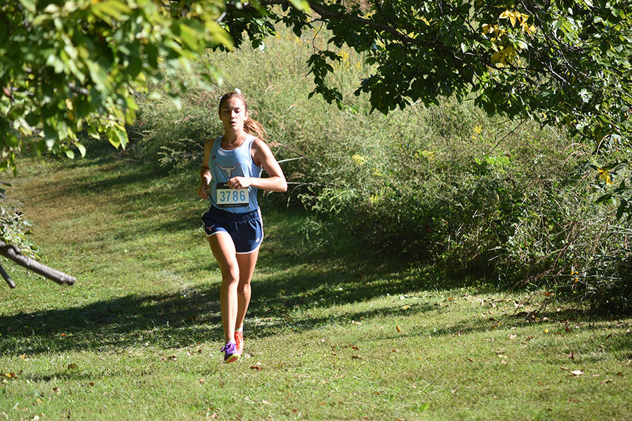 Leading the race, senior Chloe Hershenow competes in the conference championship. Hershenow plans to continue her running career at the university of Tulsa in the fall. “Being able to run collegiately is a culmination of having coach Cutelli and Coach John because they are both great coaches and who have pushed me and having the team I have had; they have really supported me,” Hershenow said. 