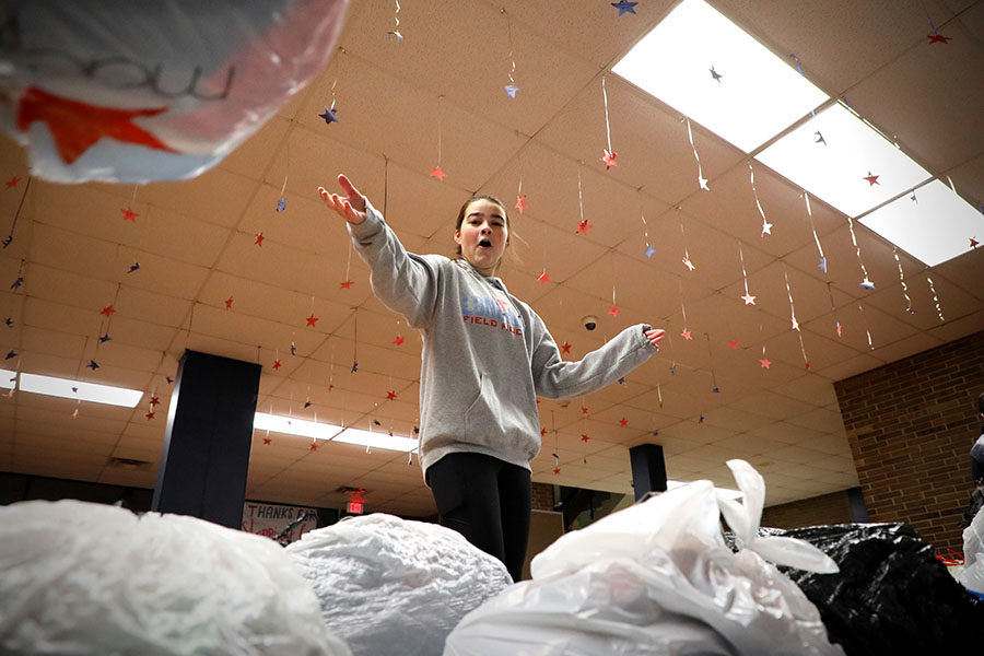 Bringing down bags of donated clothing for the Quill & Scroll Clothing Drive, senior Olivia Riemer tosses them in front of the main entrance kiosk. The counselor and yearbook adviser from St. Clair High School came to pick up the donations to replenish their community closet. “When they came to pick up the clothes, it was overwhelming to see how appreciative they were of all of the donations,” Riemer said.  “We got a lot more donations than what we were anticipating, so it took a while to load all the bags into their truck.”