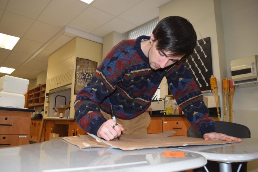 Senior Noah Wright makes a poster for the Youth Climate Strike on March 15. He has been an organizer for the walkout in St. Louis. "Climate change is a massive problem that must be addressed as soon as possible," Wright said. "I encourage all West students to get involved in their future and join us downtown."