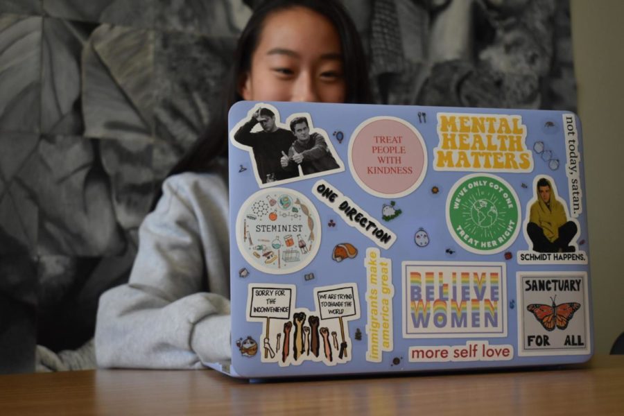 During second lunch, junior Angie Jia works on homework. As the daughter of immigrants, Jia cares for issues surrounding civil liberties and social causes and chose laptop stickers that would represent her passions. “My ‘Immigrants Make America Great’ represents my parents, who I am and who I feel should be empowered in America: immigrants. I value protecting and preserving our environment over industry so I have an environmental awareness sticker too,” Jia said. “My ‘Believe Women sticker I got around the time of the Brett Kavanaugh hearings because I strongly agreed with what Dr. Christine Blasely Ford was doing by empowering women and believing their stories.”