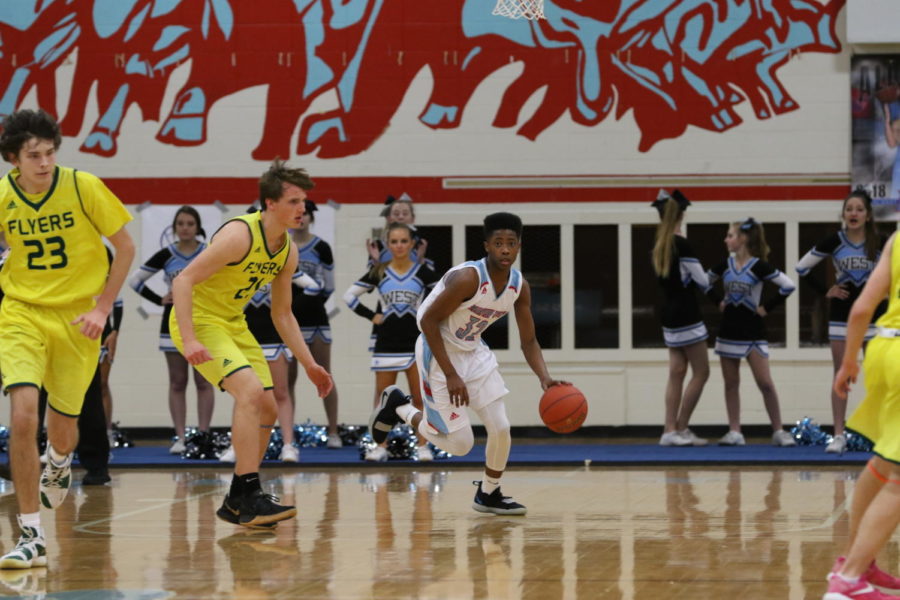 Freshman Tre Bell runs the ball up the court during the Coaches versus Cancer game against Lindbergh. Bell has been playing basketball since he was six years old. “I just try to be myself. I don’t try to go out of my role,” Bell said. “I just try to make my teammates better but at the same time make myself better.”