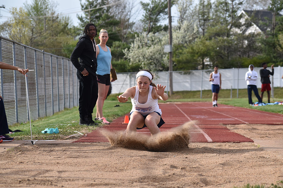 Landing her triple jump, freshman Laurel Rakers competes in a track meet against Parkway South, April 10. Rakers worked with both coaches and older teammates to perfect her jumps and cites senior Tess Allgeyer as one of her role models on the team. “I just started this year. I really liked long jumping, and my coach wanted me to try the triple jump. I loved it, Rakers said. The support from [the team] and the coaches keep you going.”