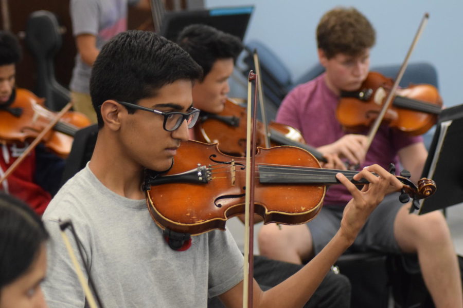 Directed by Ed Sandheinrich (not pictured), juniors Ronik Bhaskar, Dennis McMorrow and Daniel Yu play their instruments in Symphonic Orchestra. All levels of orchestra participate in the reflection by playing songs that they are able too that the seniors choose. “It’s different every day, a new adventure every day, and it keeps things fresh,” Sandheinrich said.