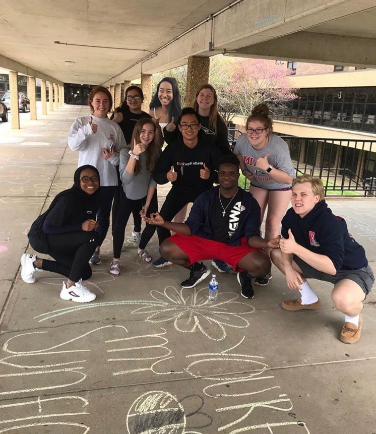 Admiring their work, students take a photo after decorating the sidewalks leading into the school Sunday, March 28. Longhorn Council wrote positive phrases and messages in bathrooms throughout the school and on sidewalks to prepare for Pay it Forward Week. “I had a fun time decorating mirrors and sidewalks on Sunday,” junior Quinn Berry said. “It’s so rewarding to spread positivity and make someones day in unexpected ways.”