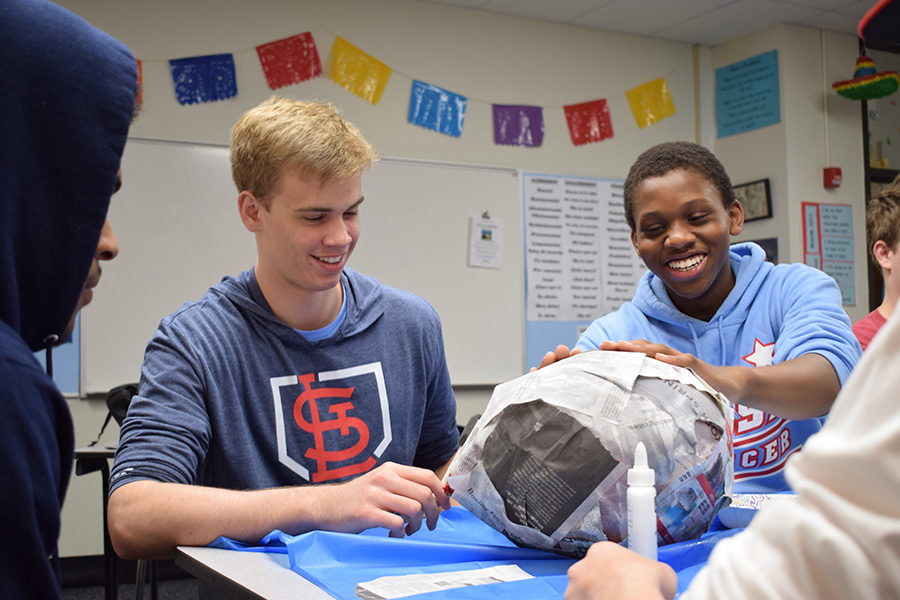 Using balloons and newspaper to construct piñatas in Eileen Rodriguez-Kiser’s Spanish II class, sophomore Logan Wich and junior Ridwan Oyebamiji laugh as they glue together their project. The class has been exploring different types of birthday celebrations in Hispanic countries. “It was really cool to take a hands-on approach to learning Spanish,” Oyebamiji said. “Instead of just sitting at a desk, we were able to be immersed in the culture, which really deepens your understanding.”