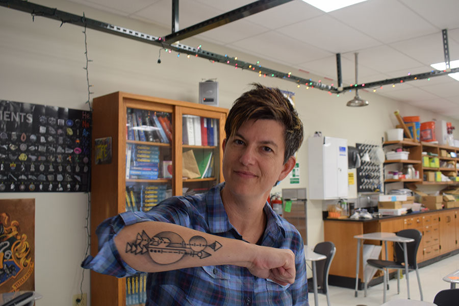 Science teacher Amy Van-Matre displays her tattoo based on a poem by Kahlil Gibran in which bows symbolize parents and arrows symbolize children. After planning the tattoo for three years, one of her students talked her into finally getting it. “My kids aren’t always going to stay with me [like] the arrows that someone shoots don’t stay with them. I think of my kids when I see [my tattoo] and it represents that they are always with me,” Van-Matre said. 