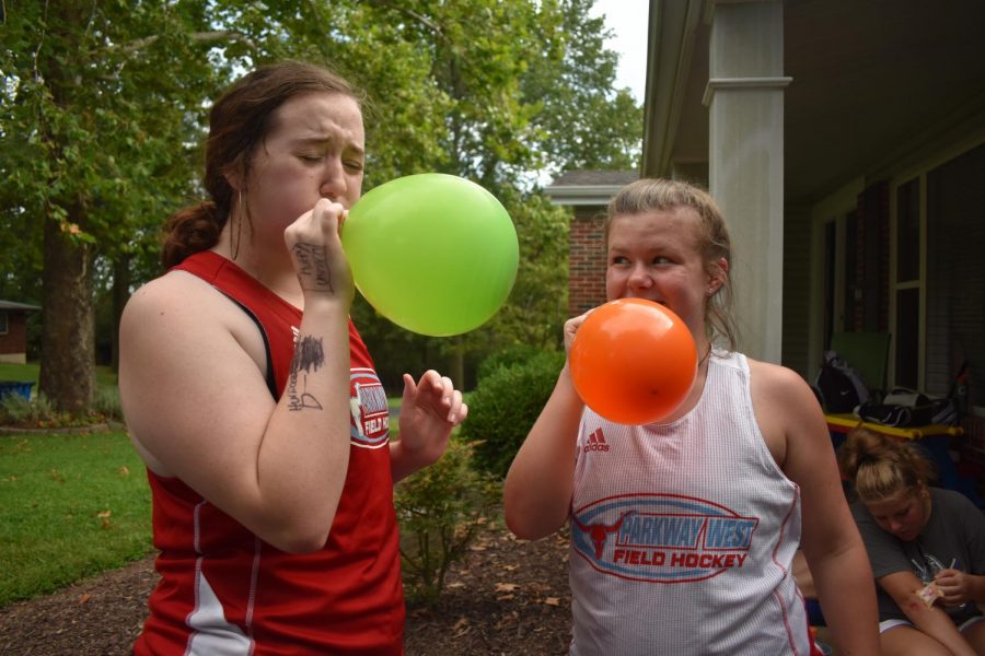 At a field hockey team dinner, sophomores Sarah Kline and Annie Zahoran blow up another balloon for a competition to see who could not let the balloon drop to the floor on Sept. 2. Members of the field hockey program met at Coach Dawn Callahan’s house for a team dinner of Italian food.  “We were playing keep it up with the balloons as a competition between our three teams, but we ended up popping all of them. I was really struggling [to blow the balloons up] but we ended up having a lot of fun anyways, Kline said. 