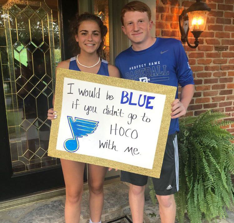 Standing on the porch of her house, freshman Cooper Walkoff displays his Blues-inspired sign to freshman Audrey Rolfing. Walkoff used the St. Louis Blues’ recent Stanley Cup victory as the inspiration behind his sign. “We both became big Blues fans during the Stanley Cup finals, and I thought it would be a unique way to ask,” Walkoff said. “It was a fun experience when I went because I was with two of my friends, and I brought her a miniature Stanley Cup while they played Gloria in the background.”
