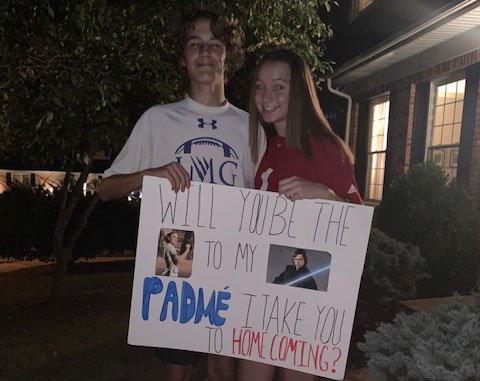 Posing outside her house, freshman Derrien Gatchel asks freshman Makinsey Drake to Homecoming. Gatchel and Drake are both fans of the Star Wars franchise. “I looked on Pinterest for Star Wars homecoming signs and saw a similar idea to mine,” Gatchel said. “It didnt take too long to make, and I just made it in my living room.”
