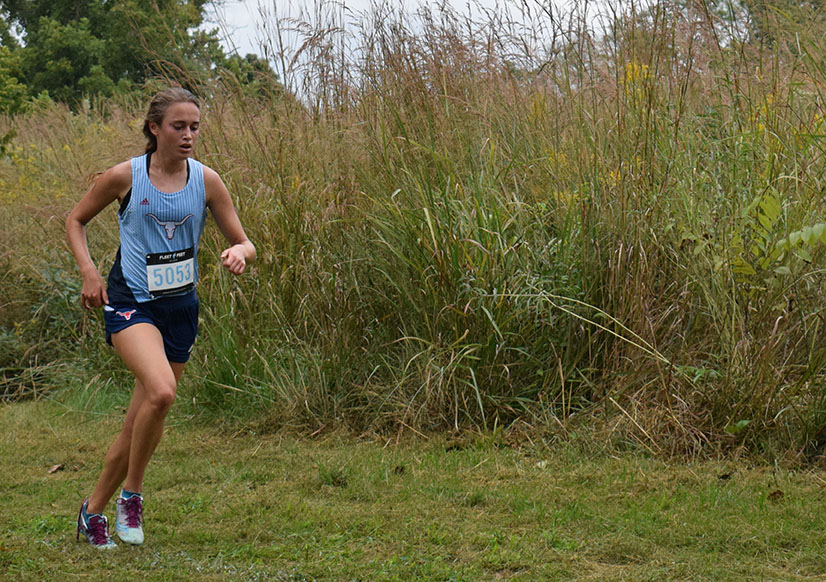 At+the+Sioux+Passage+cross+country+meet+Sept.+21%2C+junior+Emily+Sipp+rounds+a+bend+in+the+course.+Sipp+has+been+running+since+second+grade+when+she+began+a+track+program+through+her+church.+%E2%80%9CMy+favorite+part+is+probably+just+%5Bbeing+with%5D+the+people+that+I+get+to+run+with+daily.+Outside+the+sport%2C+we+probably+wouldn%E2%80%99t+really+all+be+friends.+When+you+get+to+know+each+other%2C+and+push+each+other+and+work+hard+together%2C+its+really+fun+to+%5Bshare%5D+that+experience+with+other+girls%2C%E2%80%9D+Sipp+said.+