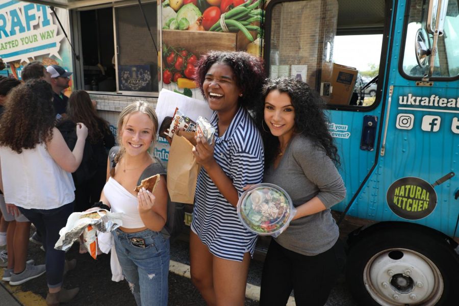 Getting ready to bite into food truck menu options from UKRAFT Eats, junior Claire Middleton and seniors Aaliyah Weston and Reema Alhachami learn about the logistics of owning a food truck from owner and operator Matt Ratz. Marketing I teacher Holly Weber brought in Ratz to guide students as they create their own food trucks for their class projects, and inspire them to set and accomplish goals. "There are so many different options of what you can eat, or what [the truck] can look like and hearing about how it started was so interesting to me,” Middleton said. “[Ratz] said specifically that you should follow your dreams, and you have an idea or a vision of something you really want to do, go for it and go all in. It gave me more of a positive outlook and if I do set my mind to something I can get there and accomplish it.”