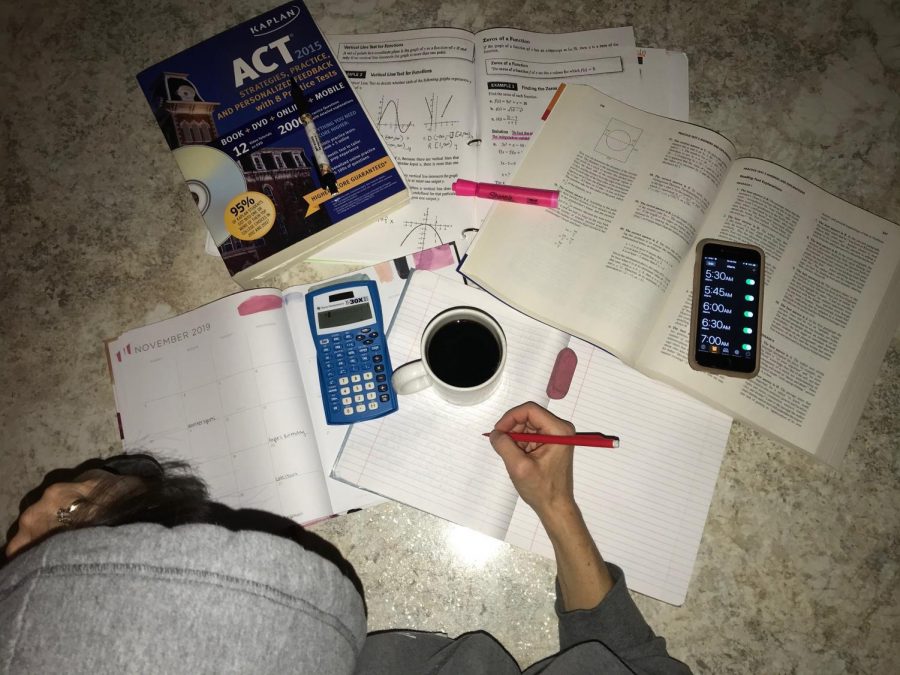 Looking over ACT books, a calendar, freshly brewed coffee and alarms for the morning, a student prepares for a night of studying. 