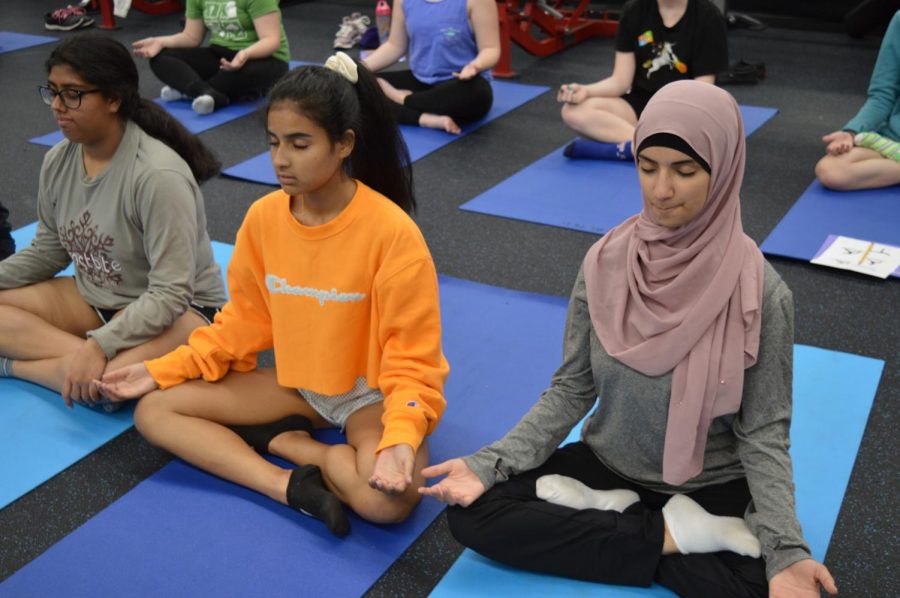 Junior Ayah Maali meditates as she tries to calm her mind. This is the first year Yoga for Fitness and Wellbeing is being offered at the school. “I learned more of how to be calm and how to relax and take your mind off stressful situations in life,” Maali said. “I [also] learned the term tadasana, and it means to be relaxed and meditated. You just sit down, cross [your legs] and your mind is off; you’re not thinking about any stressful homework or anything related to that.”