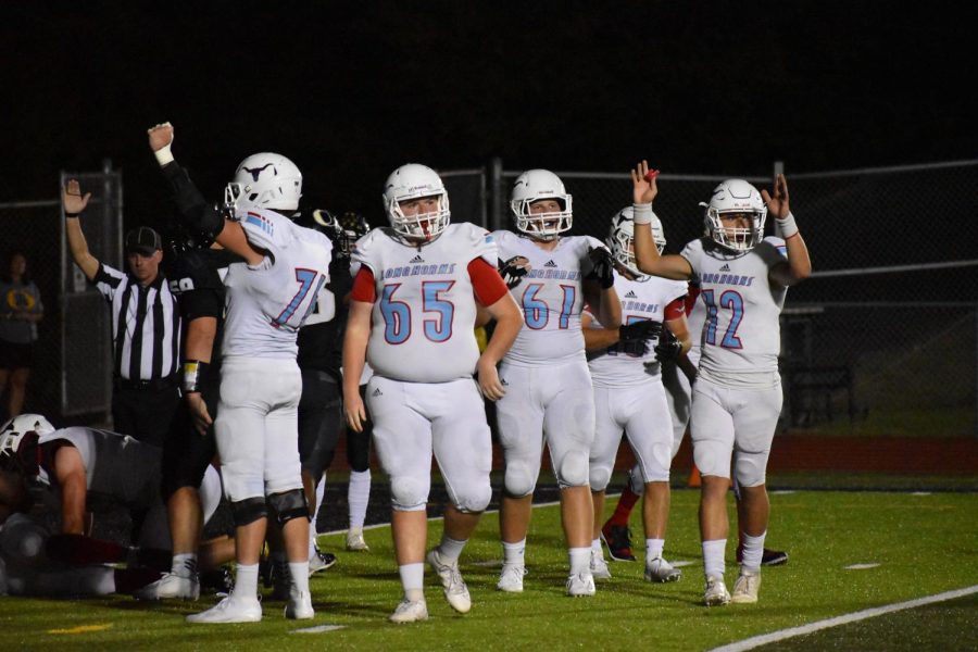 Raising his hands in the air, junior quarterback Isaac Kittrell celebrates a touchdown. The team defeated Oakville 28-0 Sept. 6, and as they prepare for districts, they hope to have a similar outcome. “If we follow our assignments, make the right decisions and overall play well, we’ll have the potential of making a deep run,” Kittrell said.  