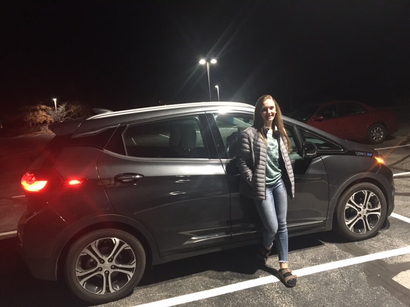 Freshman+Ashlyn+Gillespie+stands+next+to+her+family%E2%80%99s+electric+car+in+the+parking+lot.+Her+family+invested+in+this+car+so+that+they+could+be+more+environmentally-friendly.+%E2%80%9CI+honestly+hope+that+my+family+and+I+can+show+people+it%E2%80%99s+not+weird+to+get+an+all-electric+%5Bcar%5D+or+a+half+and+half+like+the+Prius.+If+that+kind+of+car+is+in+my+price+range+then+I+do+hope+to+get+an+electric+car+as+my+first+car%2C%E2%80%9D+Gillespie+said.