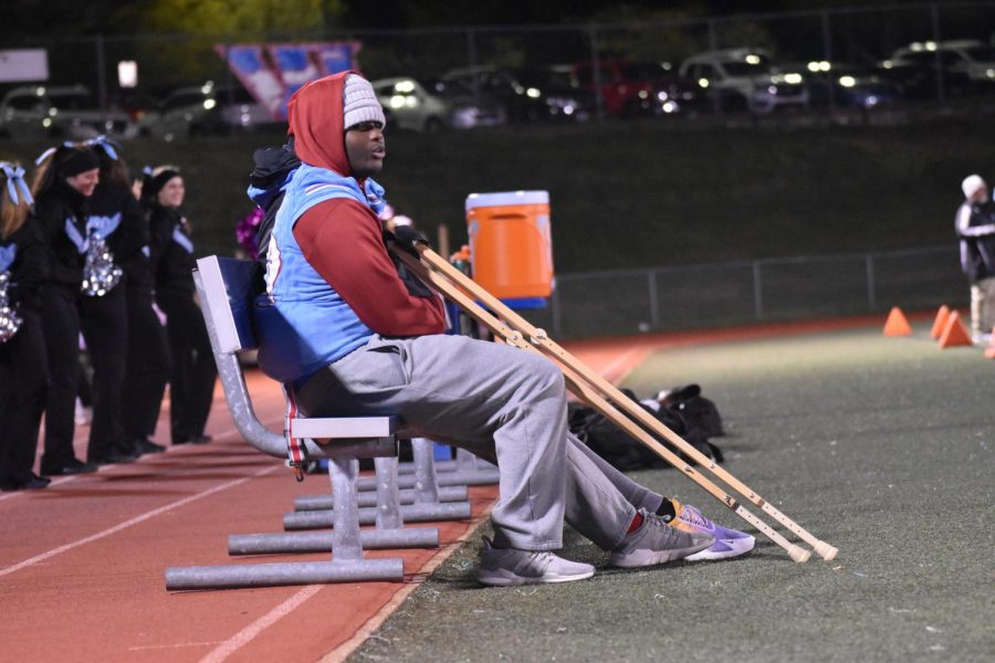 Junior Tim Nelson sitting on the sidelines during the  varsity football game while watching and supporting his          
teammates. 
