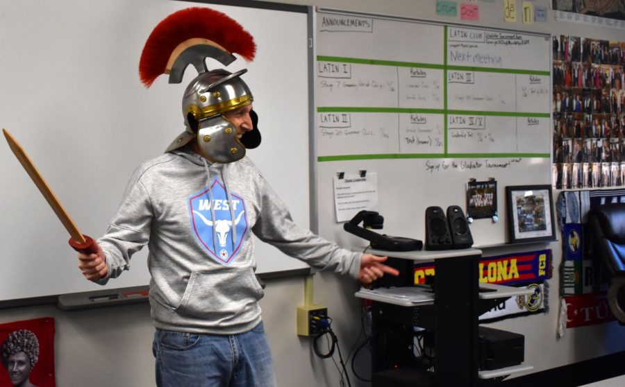 Latin+teacher+Tom+Herpel+entertains+students+with+a+sword+and+a+gladiator+helmet.+In+class%2C+Herpel+focused+on+the+learning+process+while+making+the+class+enjoyable+for+students+and+involving+cultural+experiences.+%E2%80%9CI%E2%80%99ll+always+remember+the+vocative+tense%2C+or+command+tense%2C+because+we+learned+it+and+vocab+by+doing+yoga-like+the+game+Twister%2C%E2%80%9D+Rutledge+said.+