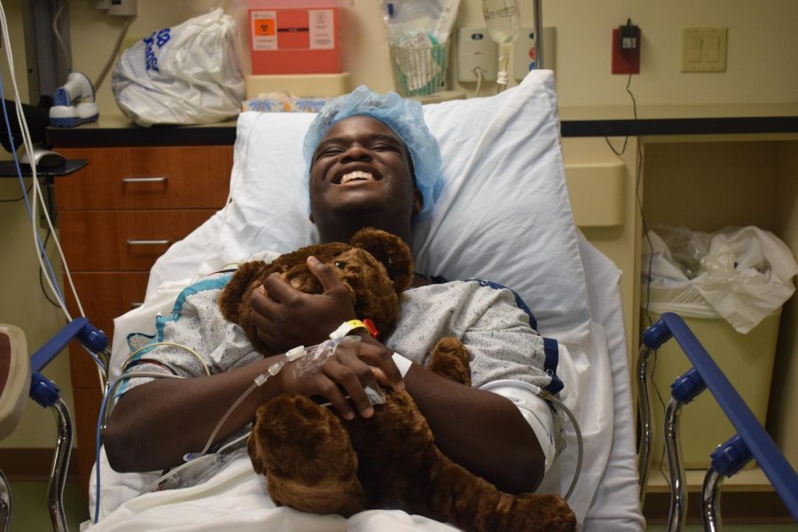 Smiling before surgery, junior Tim Nelson holds a teddy bear. Nelson was excited to undergo surgery so that he could begin the long recovery process. “After the pain goes away, I know [the  recovery process] will be easy,” Nelson said. “I just need to have patience, and that's kind of something I don't have all the time.”