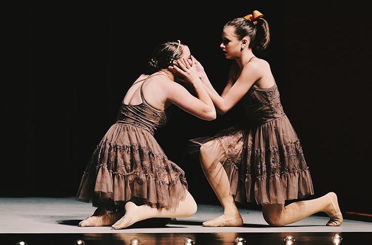 Junior Zoe DeYoung dances alongside her teammate at the Kids Artistic Revue competition. The competition was held in the auditorium at John A. Logan College, and was her second time competing at this competition. “The competition was one of the bigger ones our team had been to,” DeYoung said. “I remember putting on a heating pad after I danced because my back pain had been so bad.”