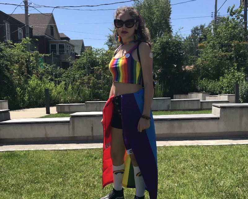 Freshman Rainier Neuwirth-Deutsch poses with a gay pride flag wrapped around their waistband while getting ready for the parade to begin. They covered their outfit with rainbows from head to toe. “[The LGBTQ+ community] is so welcoming, you never feel out of place,” Neuwirth-Deutsch said.
