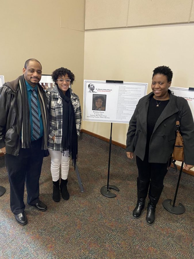 Junior Bri Davis stands with her father Ywain Davis and mother Deandria Davis as she entered the reception. Davis poem and picture were featured at the enterance.