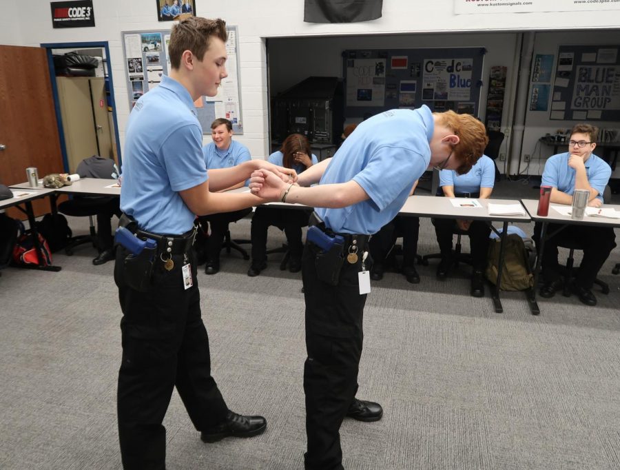 Perfecting the right way to handcuff someone, junior Jake Braymiller learns  how to be a police officer. This is Braymiller’s first year attending the program, but he plans to continue next year. “This program really helps you get career ready for whatever it is that you want to pursue, and it’s really cool how they train you and get you ready for what’s coming after you graduate,” Braymiller said. 