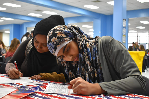 Filling out the information on the registration form, seniors Fariha Hossain and Muneebah Qayyum register to vote at the voter registration drive. The Feminist Club, with the League of Women Voters held the event Wednesday, Jan. 29 and registered 73 students. “If you have an option to vote and support something, you should,” senior Fariha Hossain said. “You can use your voice to help people.”