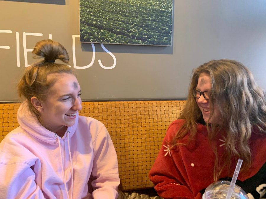 Juniors Bella Allgeyer and Reese Berry laugh over breakfast before heading to class. The two attended the Ash Wednesday mass at Incarnate Word Parish 7 a.m. to celebrate the beginning of the Lenten season. “It’s something that is kind of a necessity to us, that we sacrifice to show that other things are more important,” Allgeyer said.