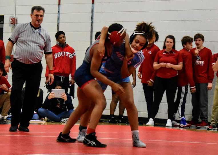 As+the+spectators+on+the+side+look+on%2C+junior+Faith+Woodall+attempts+to+get+the+upper+hand+on+her+female+opponent.+Woodall+is+a+first-year+wrestler%2C+joining+after+the+girls+wrestling+team+began+to+gain+traction.+%E2%80%9CI+really+like+it+because+they+support+each+other+in+their+endeavors+and+the+team+is+just+really+close%2C%E2%80%9D+Woodall+said.