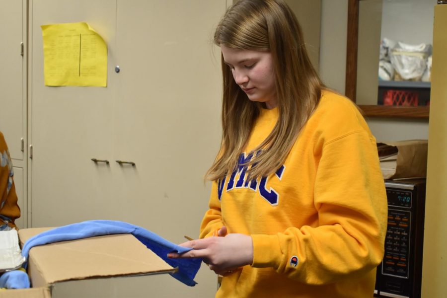 Cutting out strips of fabric for a Day of Service project, junior Brooke Gangel makes dog toys to donate to the Humane Society. Crafting for a Cause Club meets every month to choose a project that will benefit their community. “I 100%  support Crafting for a Cause,” Gangel said. “Its a fun way to get together with friends at West High but also give back to the community at the same time.”