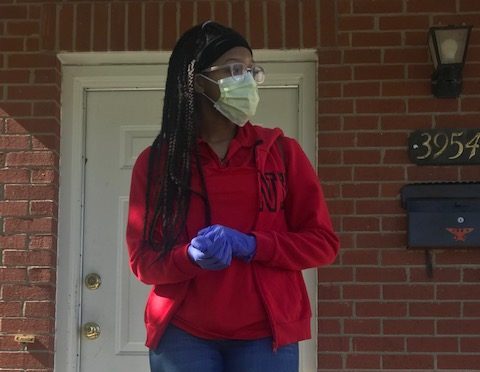 Preparing to go to her job as a bagger at Schnucks, Davis puts on her face mask and gloves. While most students are staying home, Davis goes out each day as an essential worker.